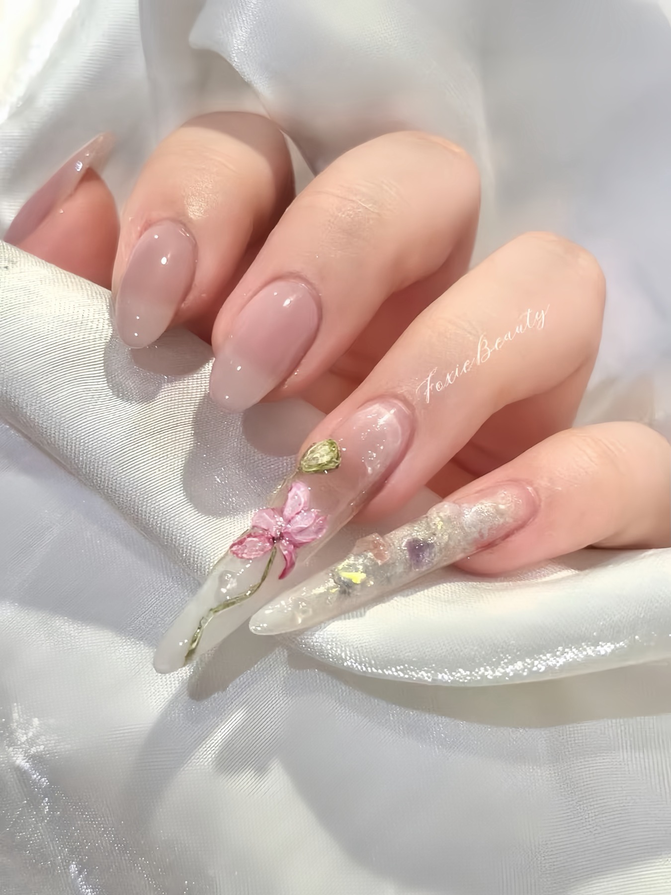 Pink floral nail art with gold and crystal details