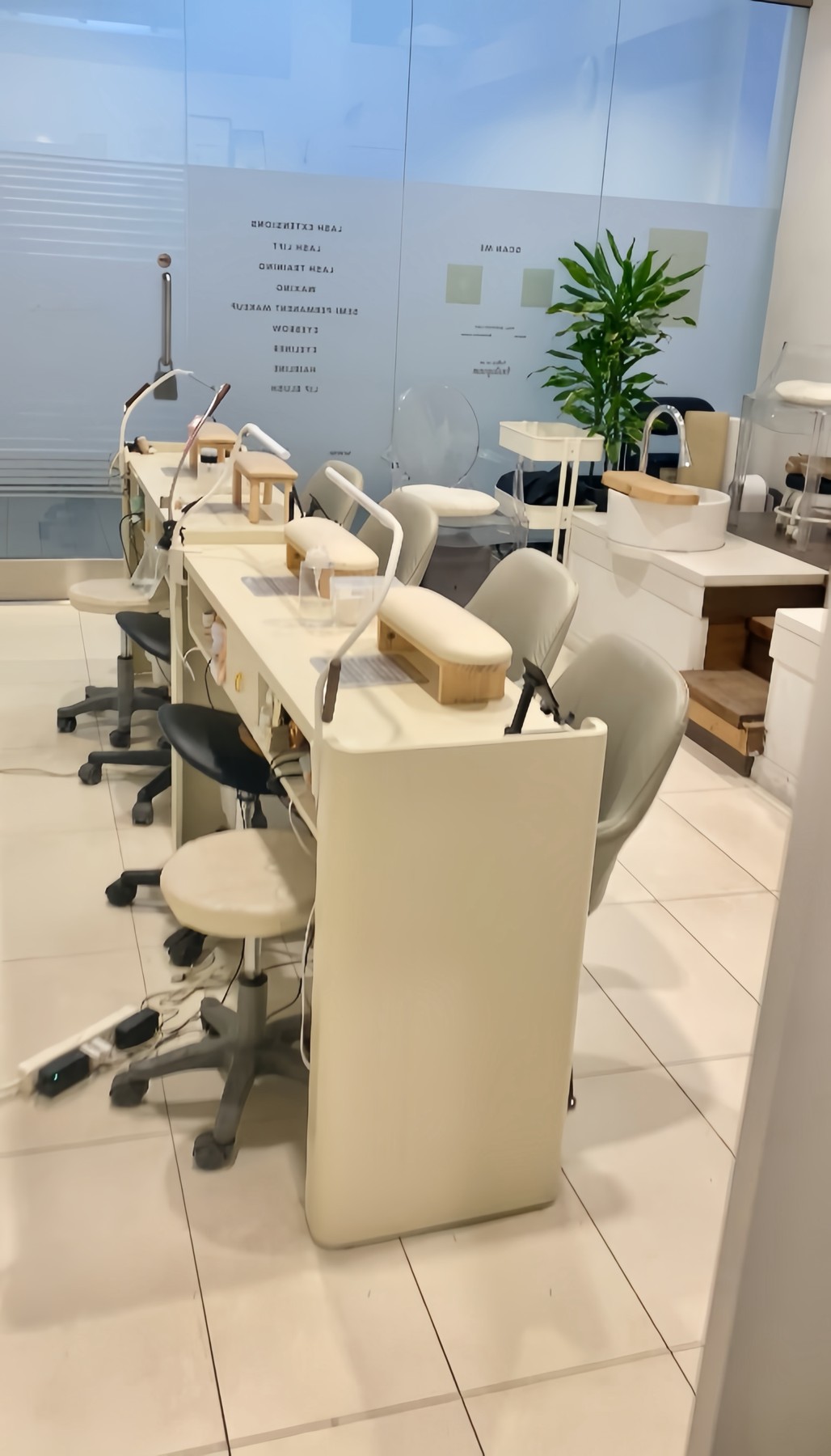 Manicure tables and cream chairs inside Foxie Beauty